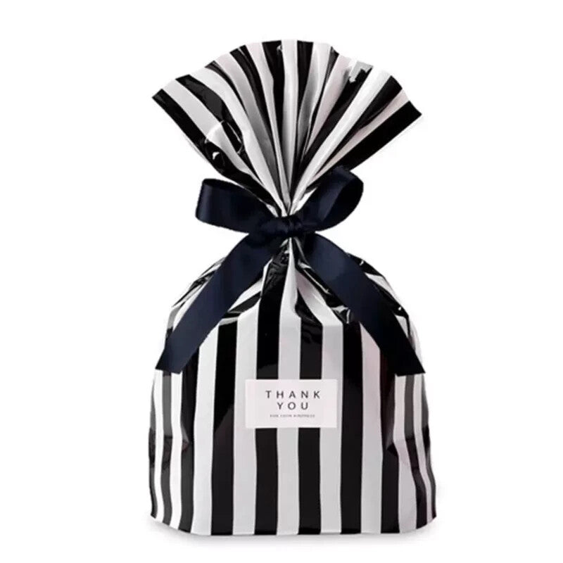 Black candy-stripe flat-bottom gift bag cinched with a black ribbon