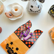 [gallery] Pumpkin bunny-ear treat bag filled with candy, flat lay