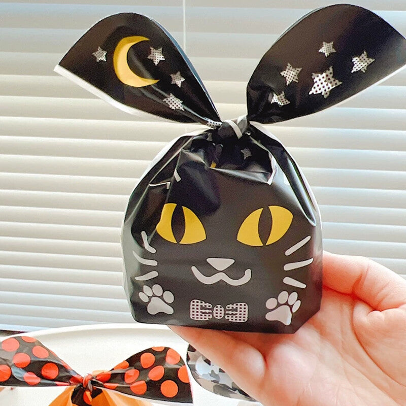 Black cat bunny-ear treat bag held in hand